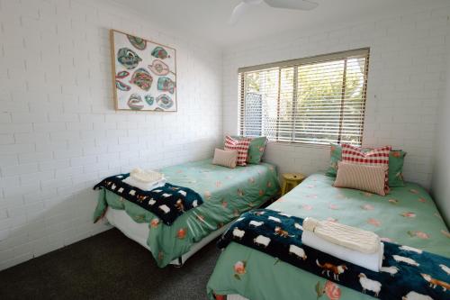 a room with two twin beds and a window at Family Fun On The Farm! Close to Kenilworth Stylish Feed Friendly Cows Breathtaking 360 Views in Obi Obi