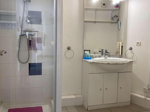 une salle de bain avec un lavabo et une douche avec un miroir dans l'établissement T2 avec terrasse, cuisine équipée, clim & wifi, proche Thermes - FR-1-553-277, à Balaruc-les-Bains