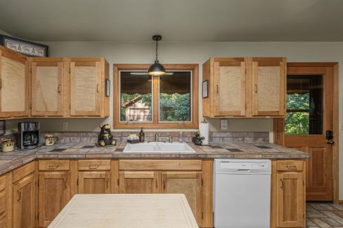 a kitchen with wooden cabinets and a sink at Bear Paw by NW Comfy Cabins in Leavenworth