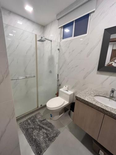 a bathroom with a shower and a toilet and a sink at Al-Mar Departamento Playero in Salinas