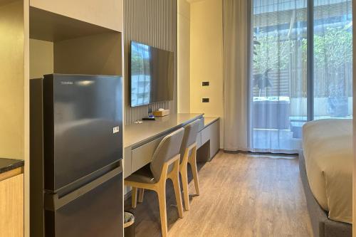 a room with a bed and a desk with chairs at La Green Hotel and Residence in Bang Tao Beach