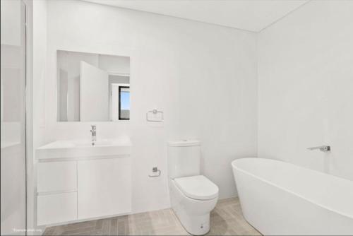 シェルハーバーにあるBright & Breezy Lakeview Retreat in Shellharbourのトイレと洗面台を備えた白いバスルーム