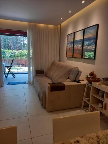 a living room with a couch and a table at Casa de Praia em Imbassaí com Varanda, Conforto e Natureza in Imbassai
