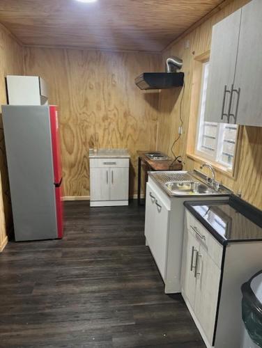 a small kitchen with a refrigerator and a sink at Cabañas Borde del Sur in El Cardonal