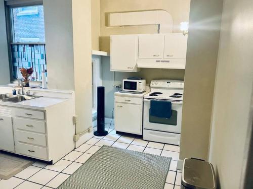 a kitchen with white cabinets and a stove top oven at Historic Downtown 3bdr with Pool Table in Louisville