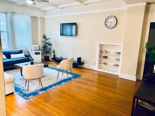 a living room with a couch and a clock on the wall at Historic Downtown 3bdr with Pool Table in Louisville