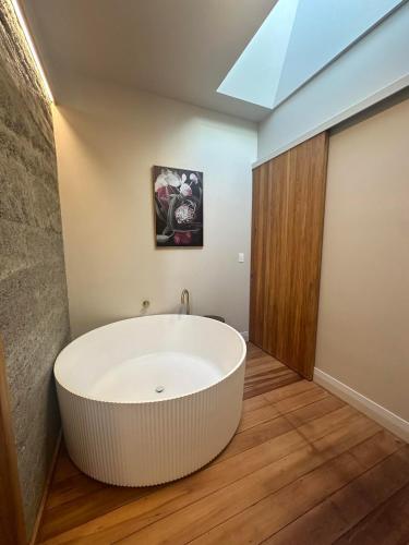 a large white bath tub in a bathroom with a skylight at The Verdict in Martinborough 