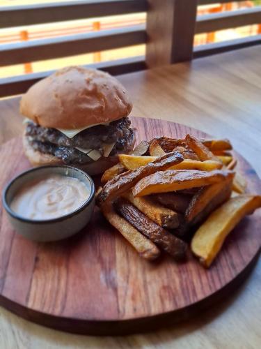 a plate with a hamburger and french fries and dip at Bukit Samudra in Lemonga