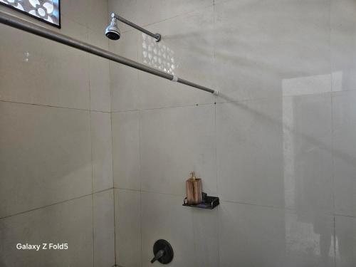 a shower with a shower head in a bathroom at ELEVEN PENIDA HOSTEL SPORTS bar in Toyapakeh