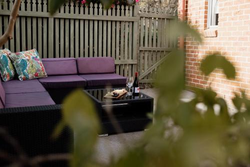 a purple couch and a table with a bottle of wine at Mountains Reach in Bowral