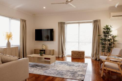 a living room with a couch and a tv at Mountains Reach in Bowral