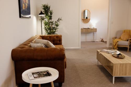 a living room with a brown couch and a coffee table at Mountains Reach in Bowral