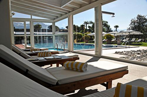 a patio with lounge chairs and a swimming pool at Villa Favorita - Parkhotel Delta in Ascona