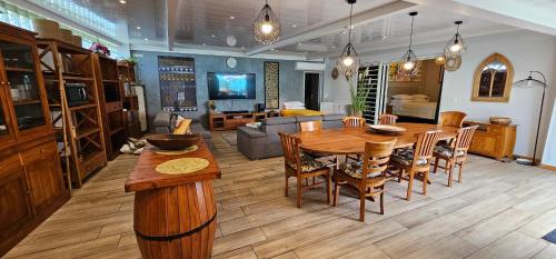 a living room with a wooden table and a couch at Tiare Pool Lodge in Pirae