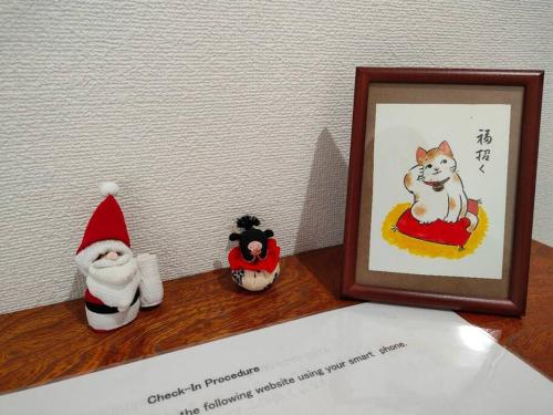 a shelf with a picture of a cat in a picture frame at 4BRHouse near Nikko Suginami Cedar Avenue in Nikko