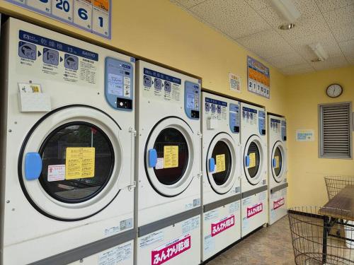 a row of washing machines in a laundry room at 4BRHouse near Nikko Suginami Cedar Avenue in Nikko