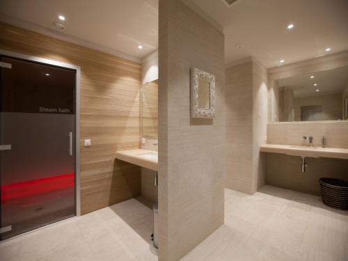 a bathroom with two sinks and two mirrors at Villa Favorita - Parkhotel Delta in Ascona
