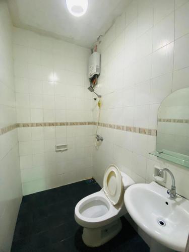 a bathroom with a white toilet and a sink at Villa puncak6 in Campaka