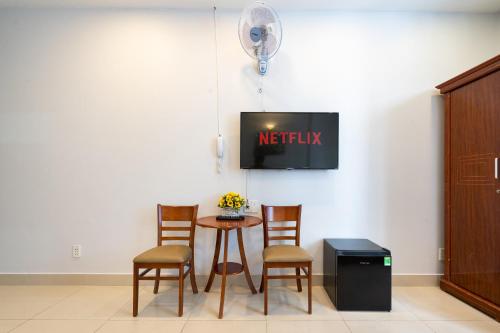 a waiting room with a table and chairs and a tv at Green Airport Hotel in Ho Chi Minh City