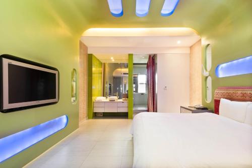 a bedroom with a bed and a tv and a bathroom at Holly Wood Motel in Pitou