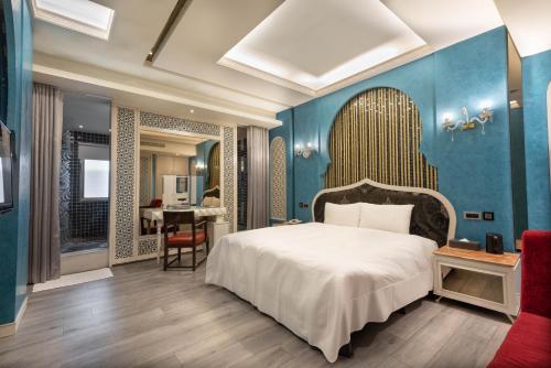 a bedroom with a bed and a blue wall at Holly Wood Motel in Pitou