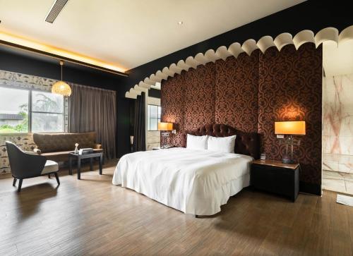 a bedroom with a large bed and a couch at Holly Wood Motel in Pitou