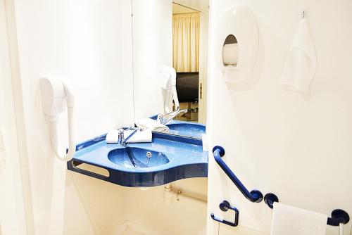 y baño con lavabo azul y espejo. en Hotel De Rosny en Tours