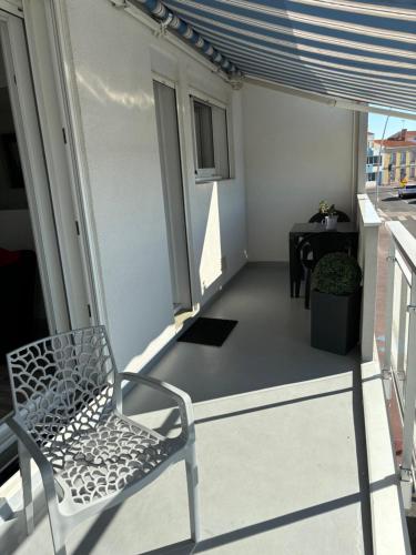 a white chair sitting on a balcony with a table at Vue panoramique PORT et OCEAN in Saint-Gilles-Croix-de-Vie