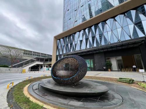 a large sculpture in front of a building at 太空舱青年寓舍深圳北站Youth dormitory Shenzhen North Branch in Lung Wa