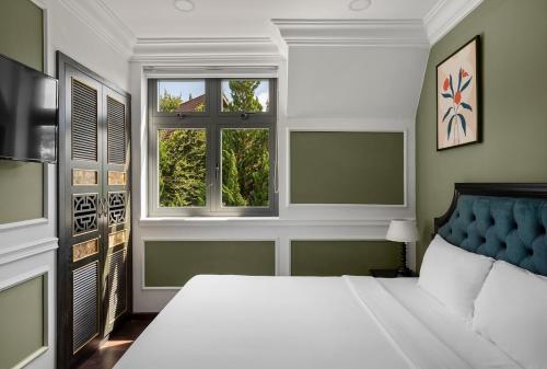 a bedroom with a large bed and two windows at The Gate Boutique Hotel Đà Lạt in Da Lat