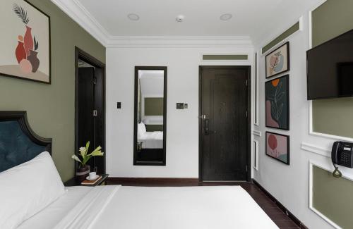 a bedroom with a white bed and a mirror at The Gate Boutique Hotel Đà Lạt in Da Lat