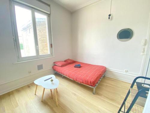 une chambre avec un lit, une table et une fenêtre dans l'établissement Le mimosa T, à Amiens