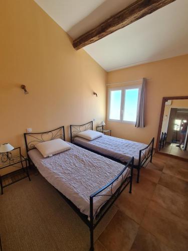 Un dormitorio con dos camas y una ventana. en Hameau De Cure, en Cazouls-lès-Béziers