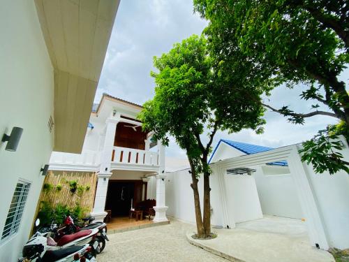 a motorcycle parked in front of a white house at Muni Residence & Spa in Battambang