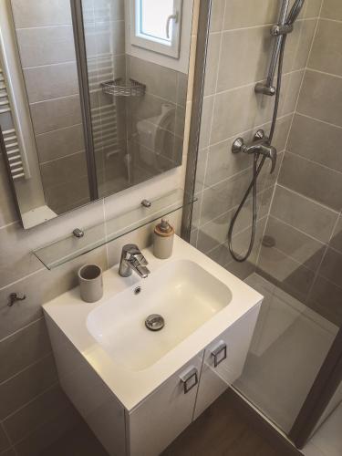 une salle de bain avec un lavabo blanc et une douche dans l'établissement Cano'Py, charmant 2 pièces avec vue montagne en cœur de ville, à Luchon