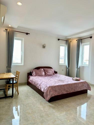 ein Schlafzimmer mit Bett, Tisch und Fenstern in der Unterkunft ST Apartment in Phnom Penh