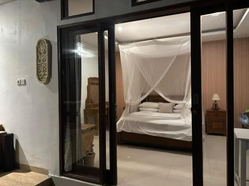 乌布Yoga House Bali的一间卧室配有一张带天蓬的白色床