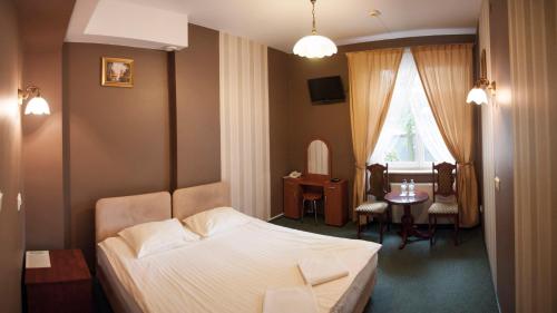 a bedroom with a bed and a table and a dining room at Hotel Nad Rzeczką in Toruń