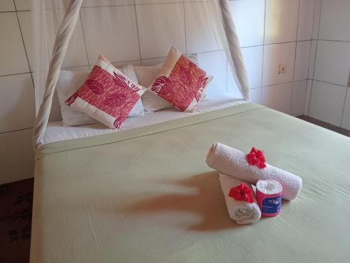 a bed with pink and white pillows on it at Tropicana Gili in Gili Meno