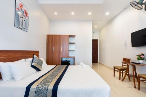 a bedroom with a bed and a table and a television at Green Airport Hotel in Ho Chi Minh City