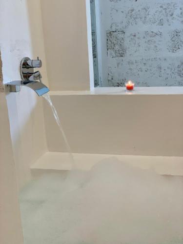 a bathroom with a water faucet with a candle at Corte Mercurio B&B in Ugento
