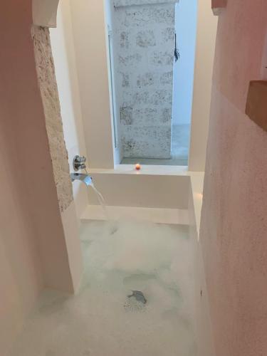 a bathroom with a window and a floor with water in it at Corte Mercurio B&B in Ugento