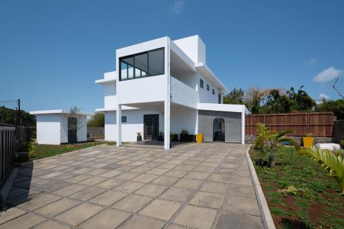 a white house with a driveway at Villa SERENITY neuve,4 chambres, 5 min de la plage in Calodyne