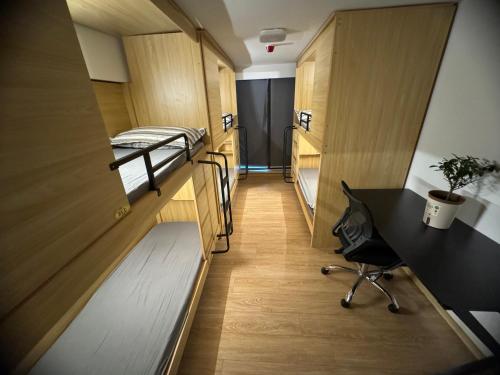 a corridor of a dorm room with bunk beds and a desk at 太空舱青年寓舍深圳北站Youth dormitory Shenzhen North Branch in Lung Wa