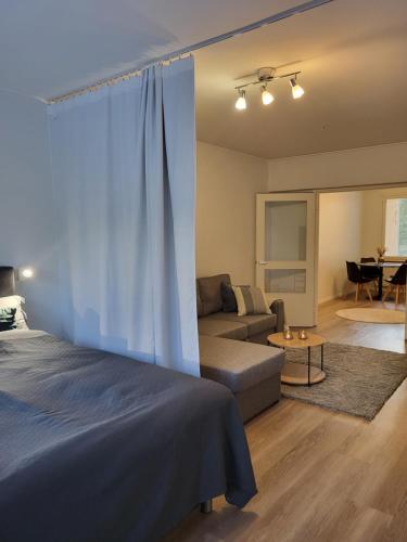 a bedroom with a bed and a couch and a living room at Kaunis kaupunkiasunto, täydellinen sijainti! in Lahti