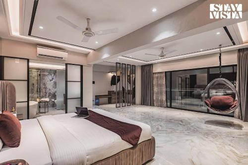 a bedroom with a large bed with a laptop on it at StayVista at Grande Prima - Pool, Theatre Room & BBQ in Panchgani