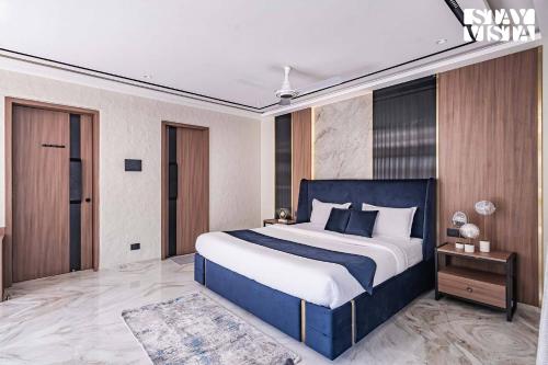 a bedroom with a large bed with a blue headboard at StayVista at Grande Prima - Pool, Theatre Room & BBQ in Panchgani