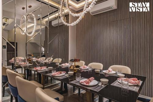 a dining room with a long table and chairs at StayVista at Grande Prima - Pool, Theatre Room & BBQ in Panchgani