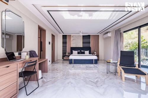 a bedroom with a bed and a desk and chairs at StayVista at Grande Prima - Pool, Theatre Room & BBQ in Panchgani