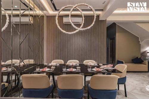 a dining room with a table and chairs and a chandelier at StayVista at Grande Prima - Pool, Theatre Room & BBQ in Panchgani